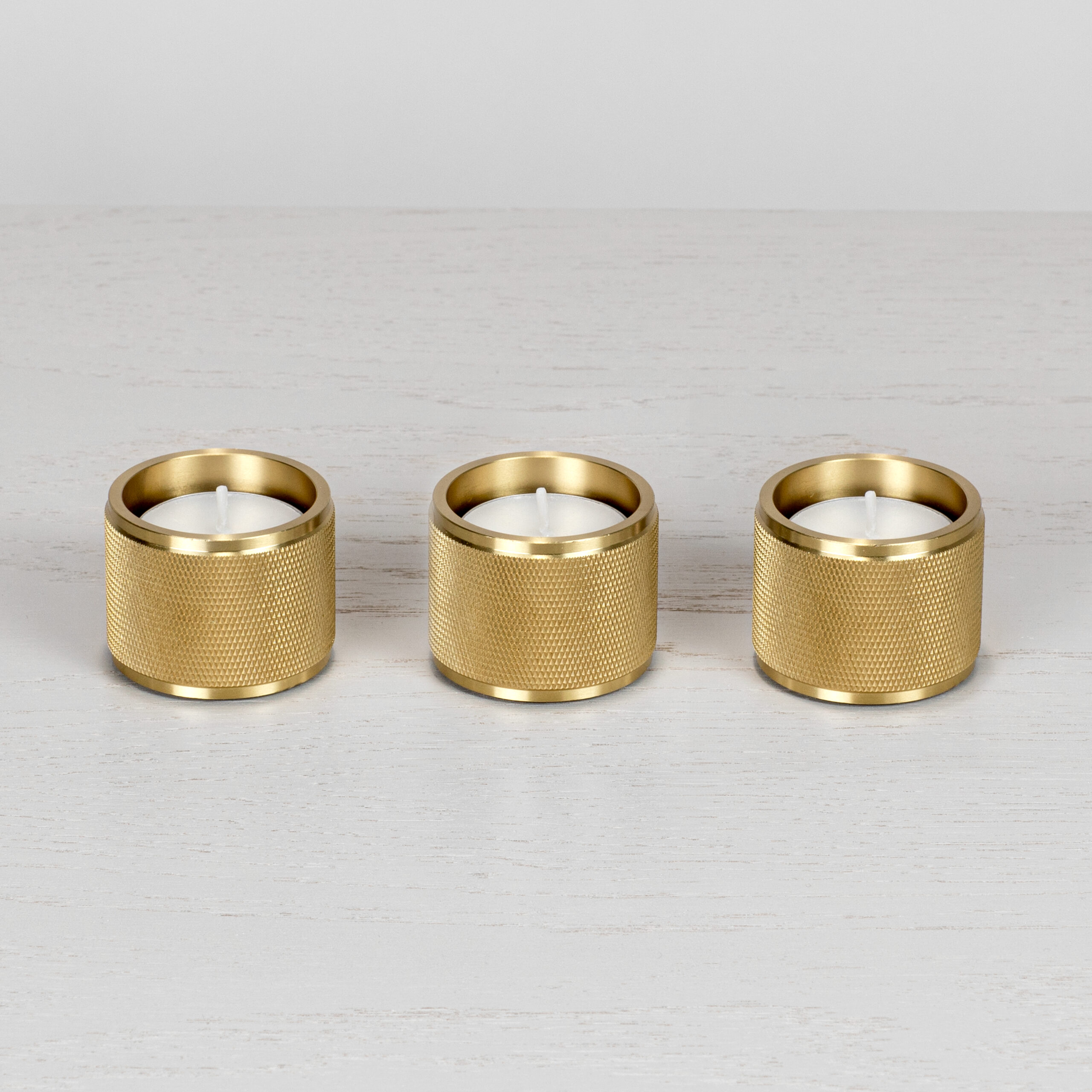 https://www.busterandpunch.com/us/wp-content/uploads/sites/2/2020/08/1.-BusterPunch_Tealight_Candle_Holders_Set-of-3_Brass_Front_off-scaled.jpg